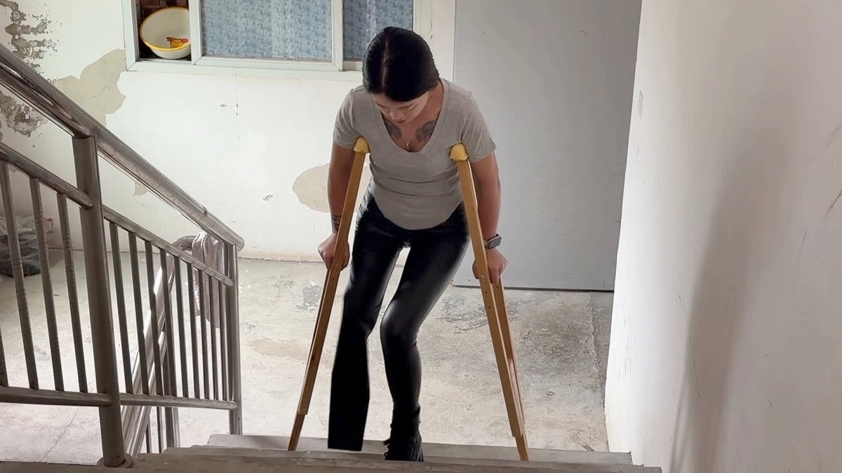 Amy: Sak Amputee Girl - Climbing stairs in leather pants and boots with crutches