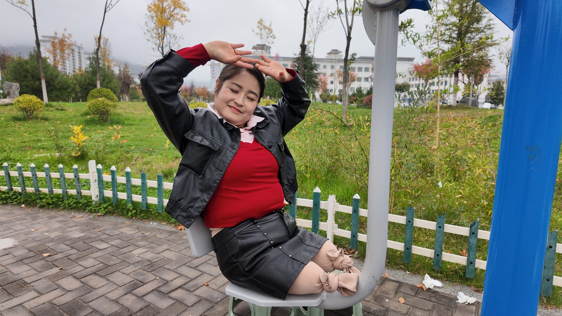Tina, an amputee girl, strolls in the park in the rain.