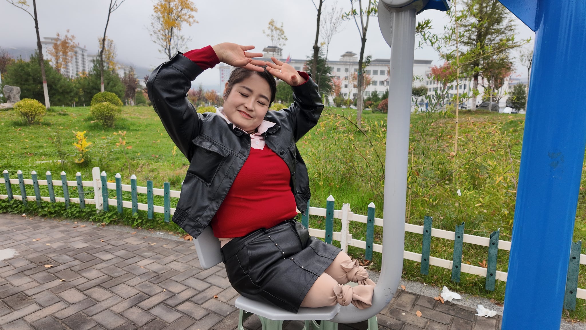 Tina, an amputee girl, strolls in the park in the rain.