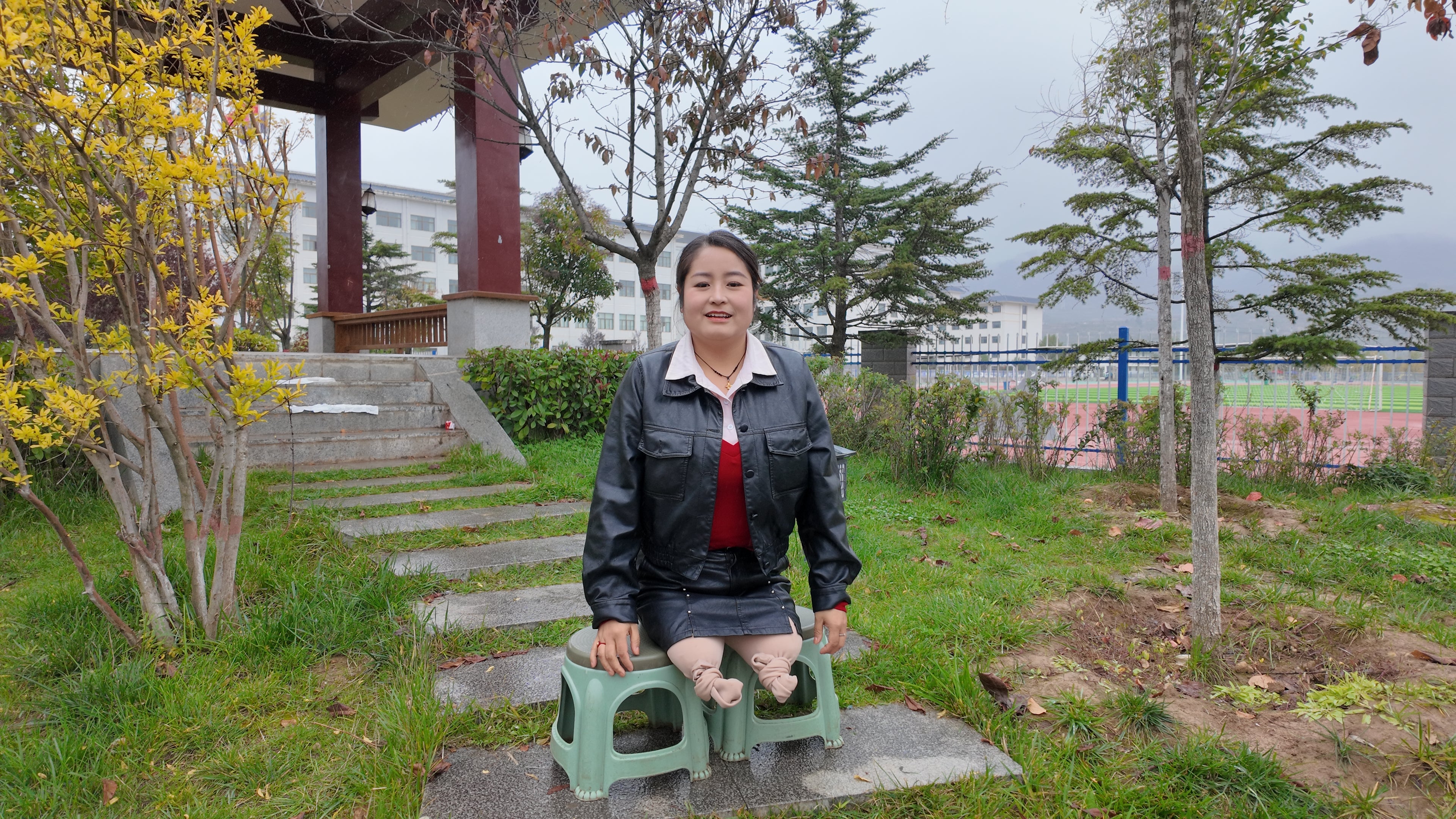 Tina, an amputee girl, strolls in the park in the rain.