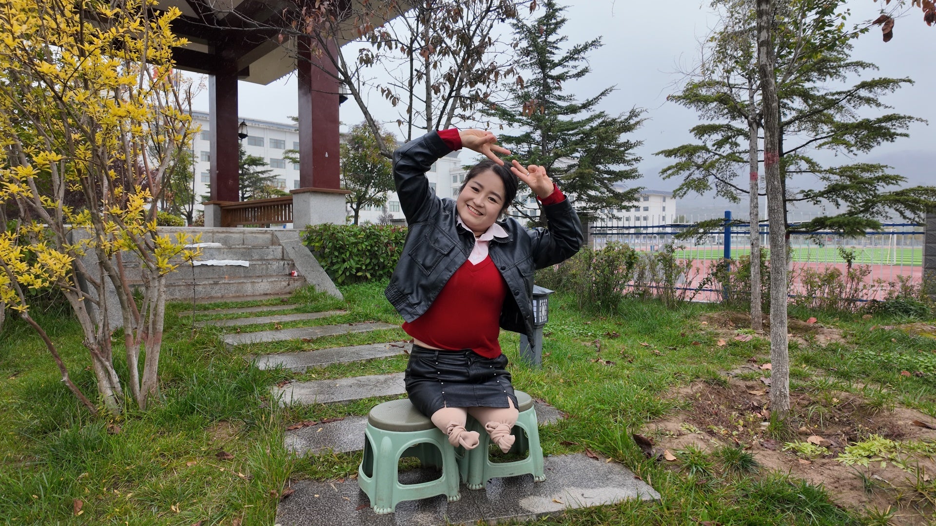 Tina, an amputee girl, strolls in the park in the rain.
