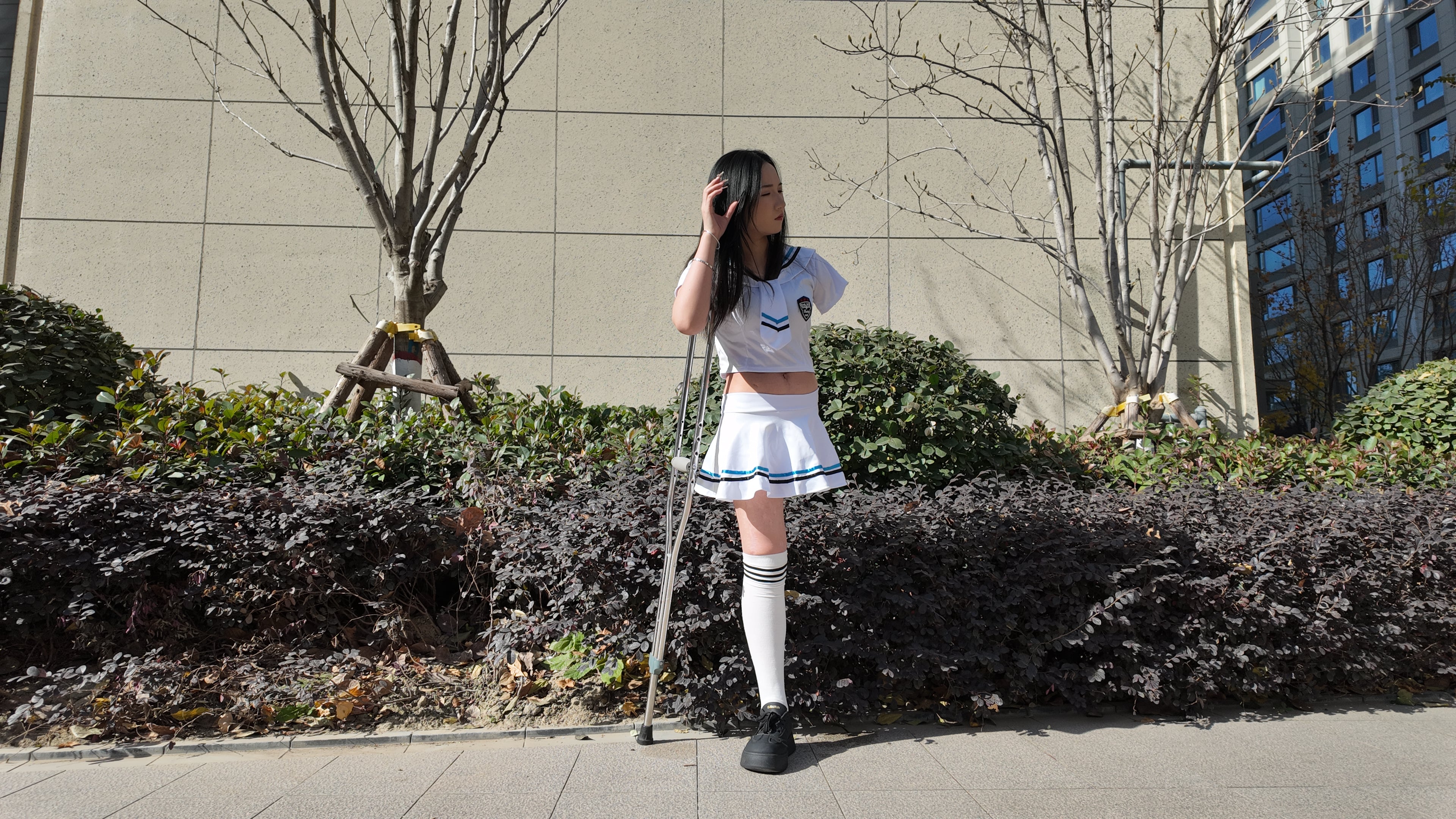 Beibei: OOE Amputee Girl, practicing walking with crutches while wearing a sailor uniform and a very short skirt.