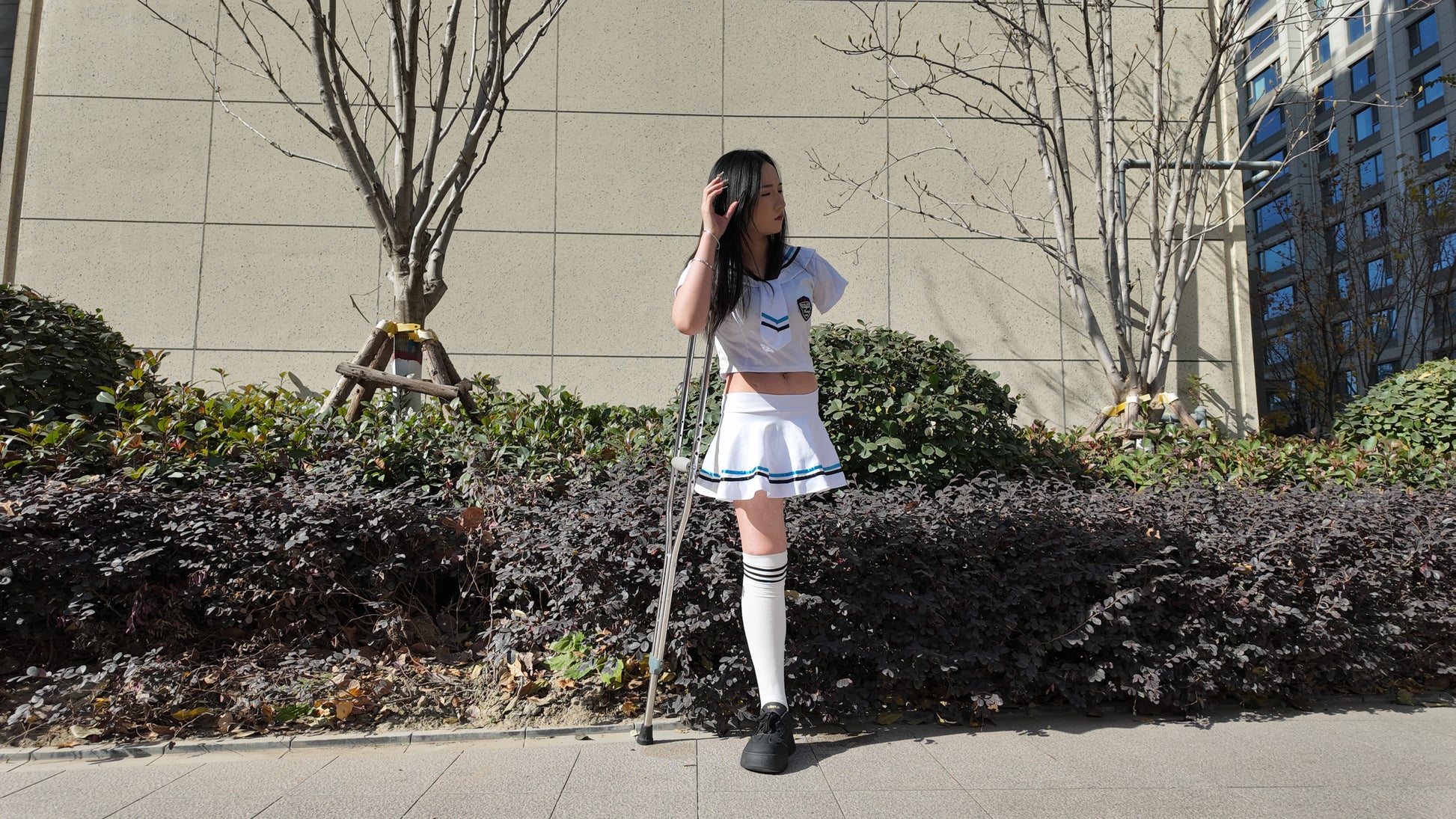 Beibei: OOE Amputee Girl, practicing walking with crutches while wearing a sailor uniform and a very short skirt.