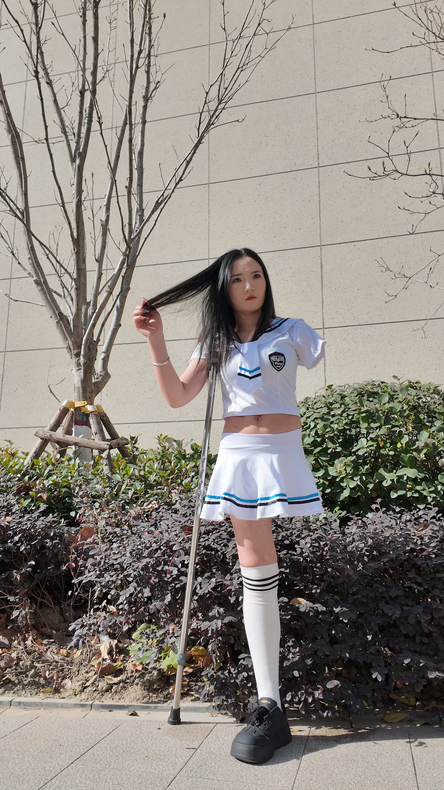 Beibei: OOE Amputee Girl, practicing walking with crutches while wearing a sailor uniform and a very short skirt.