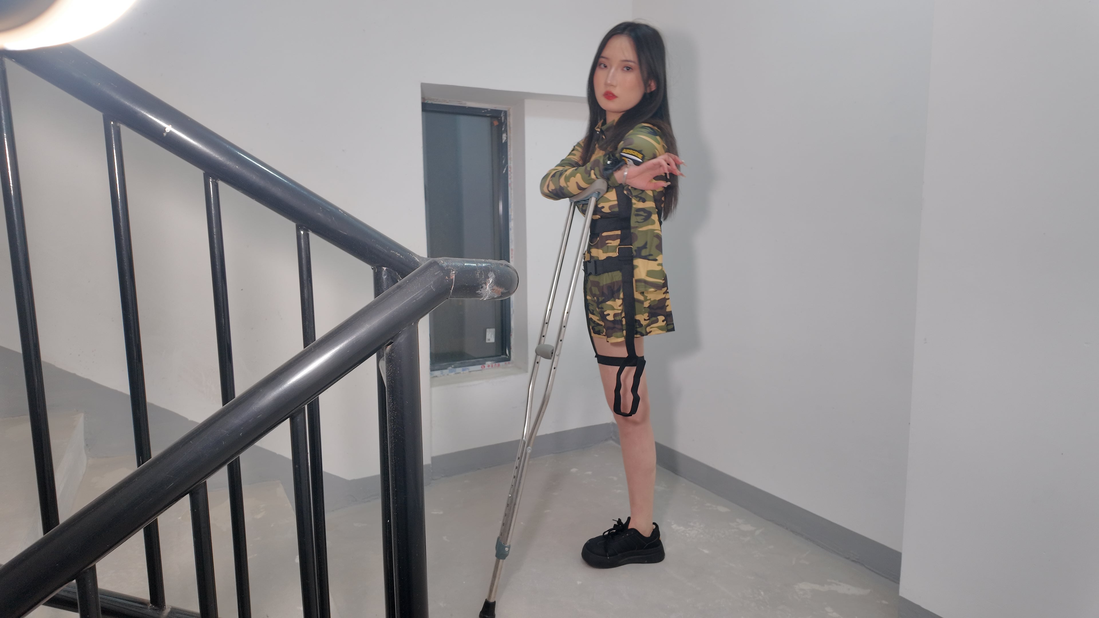 Beibei a Ooe Amputee Girl in camouflage outfit sitting in a wheelchair