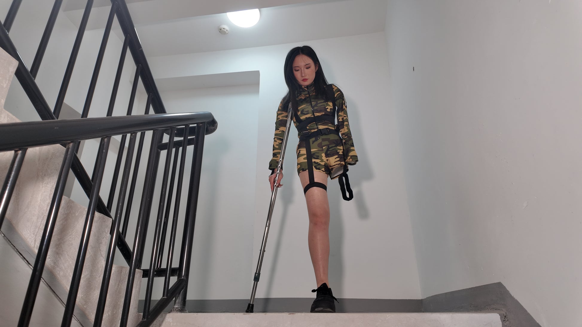 Beibei a Ooe Amputee Girl in camouflage outfit sitting in a wheelchair