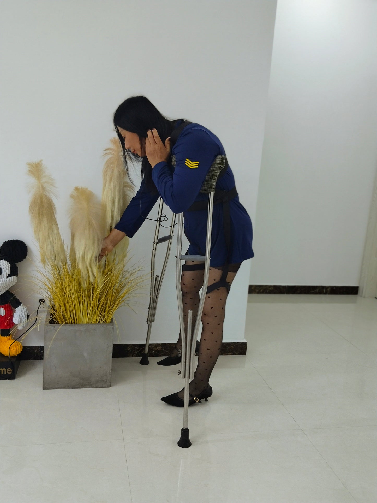 Liona, polio girl, wearing a blue uniform, black polka dot stockings, and high heels