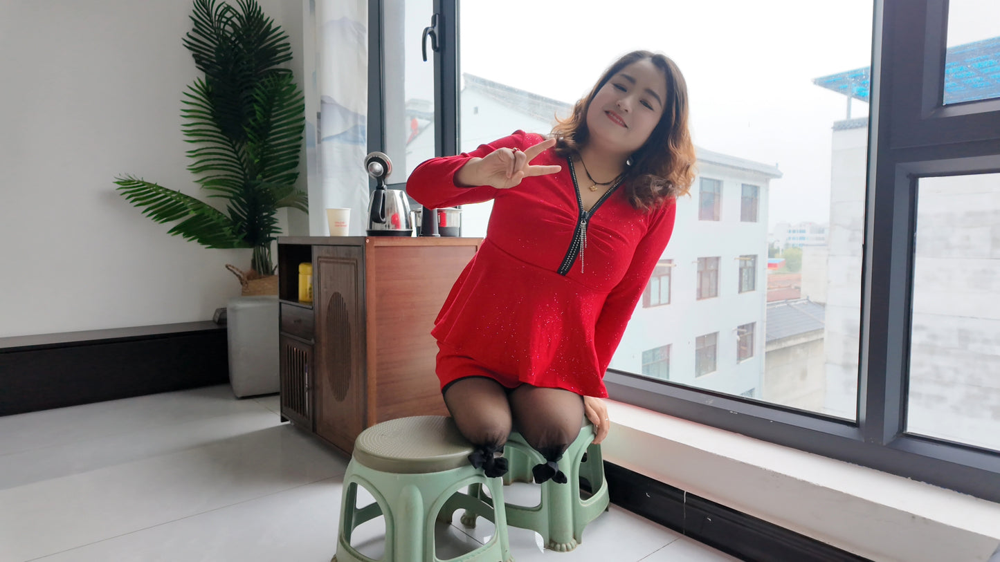 Tina, dressed in a red dress and wearing black, crawled on the bed.