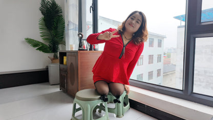 Tina, dressed in a red dress and wearing black, crawled on the bed.