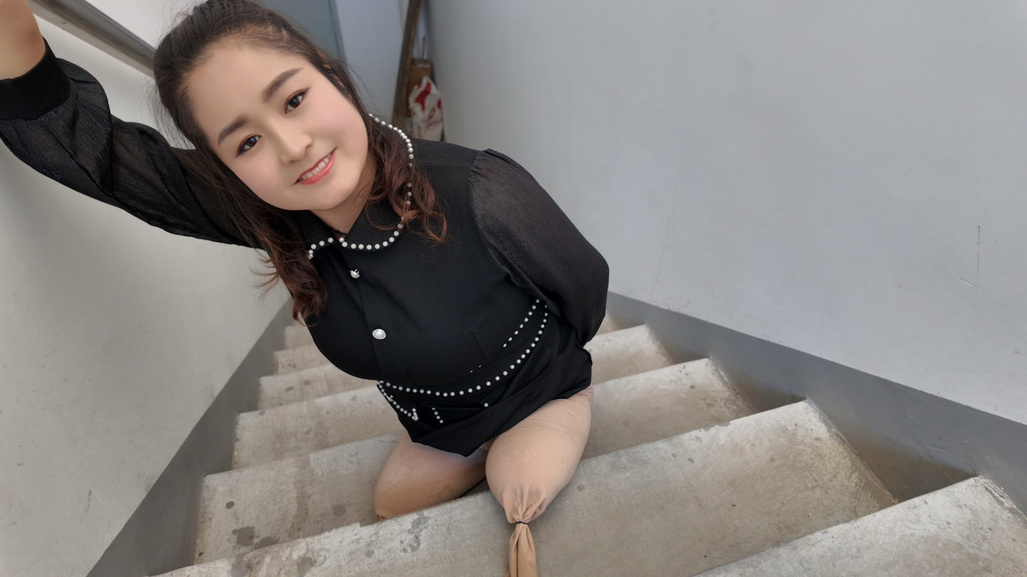 Tina, an amputee girl, uses a stool to go up and down the stairs.