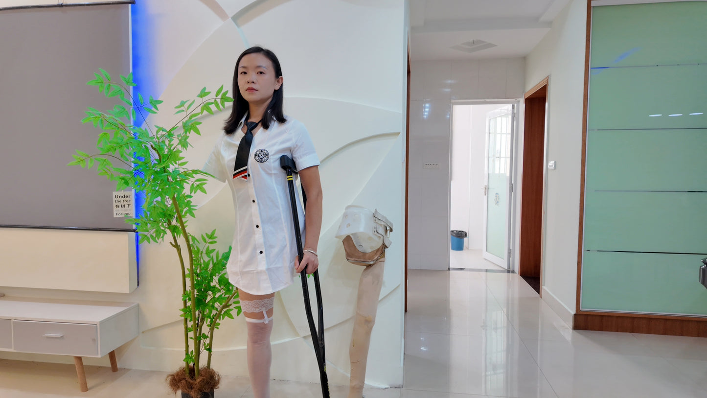 Mila: Ooe Amputee Girl - Walking indoors with crutches while wearing a white shirt and uniform.