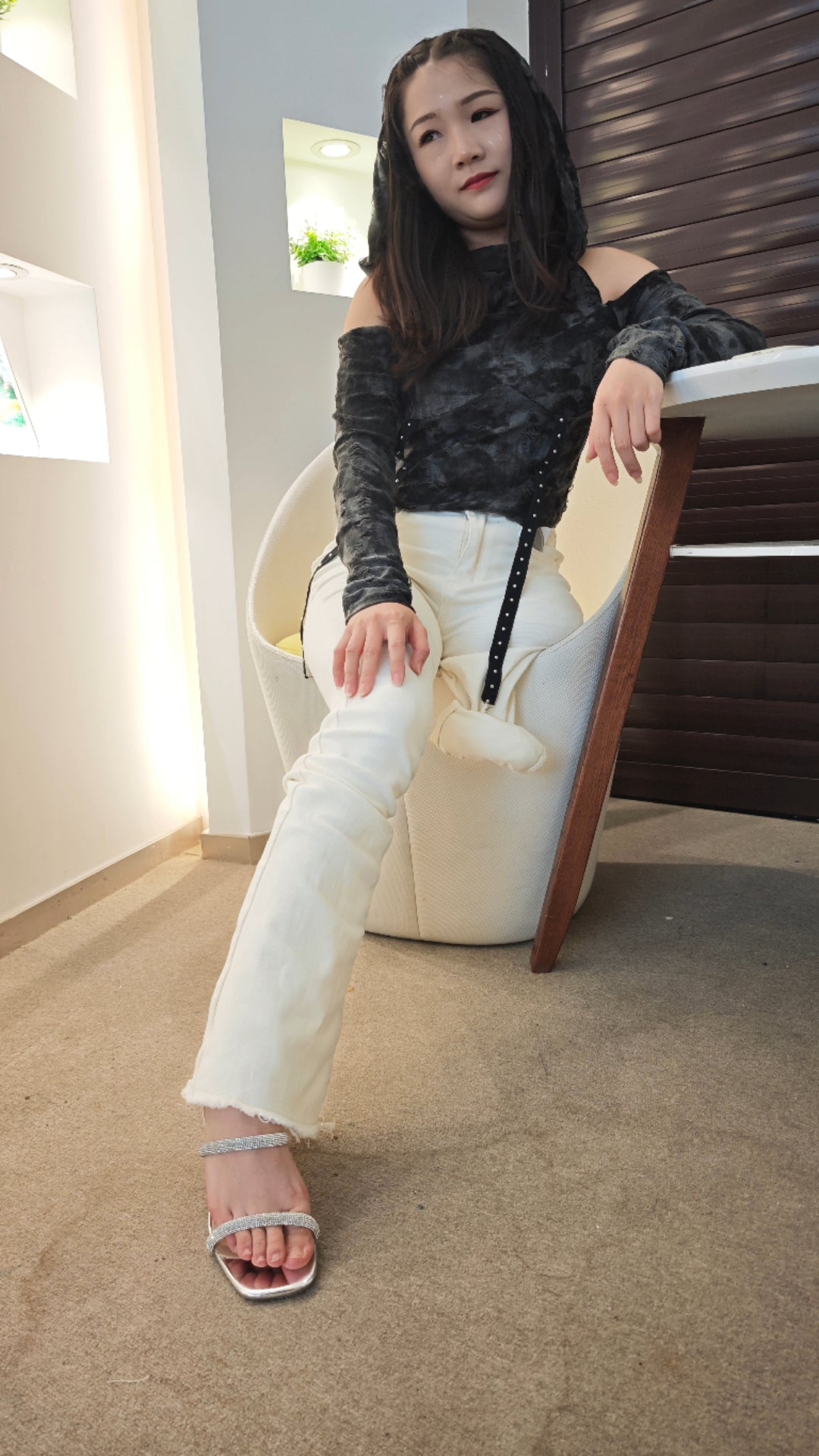 Naomi Sak, an amputee girl, is sitting on the stairs wearing black stockings.