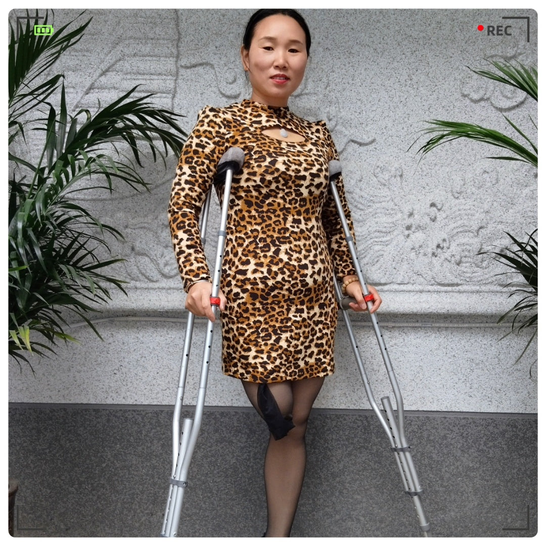 Gigi: Sak Amputee Girl, wearing leopard print stockings and using crutches