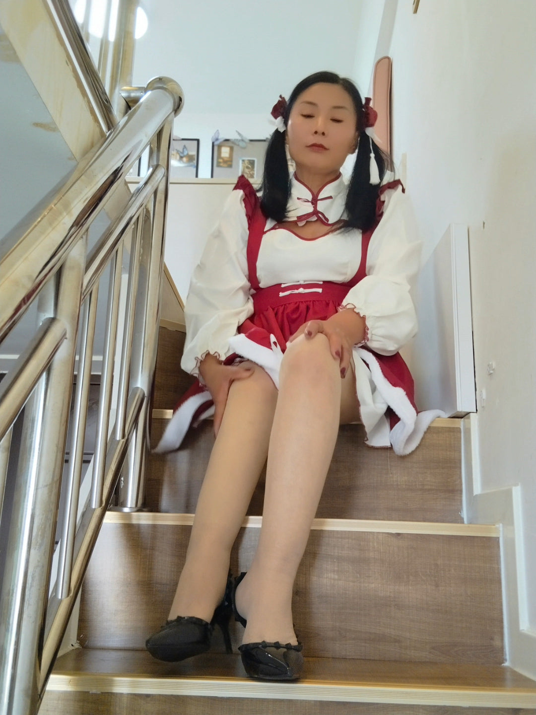 Liona, the polio girl, Red maid outfit and using crutches, goes up and down the stairs.