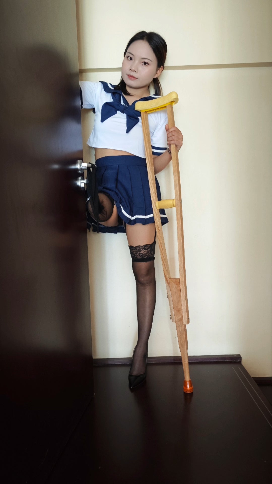 Abby: Ooe Amputee Girl, feeling her prosthetic limb while wearing a Japanese school uniform.
