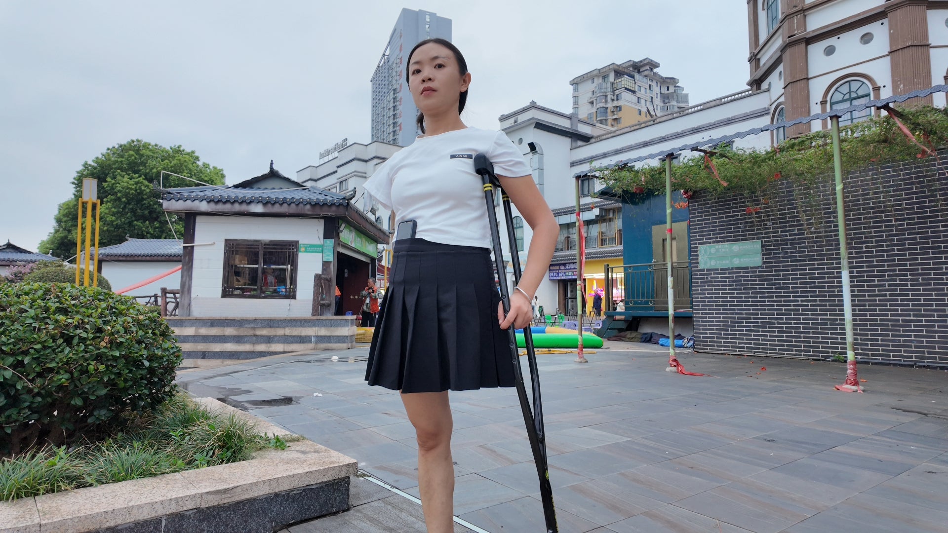 Mila: Ooe, the amputee girl, walking alone by the river with crutches.