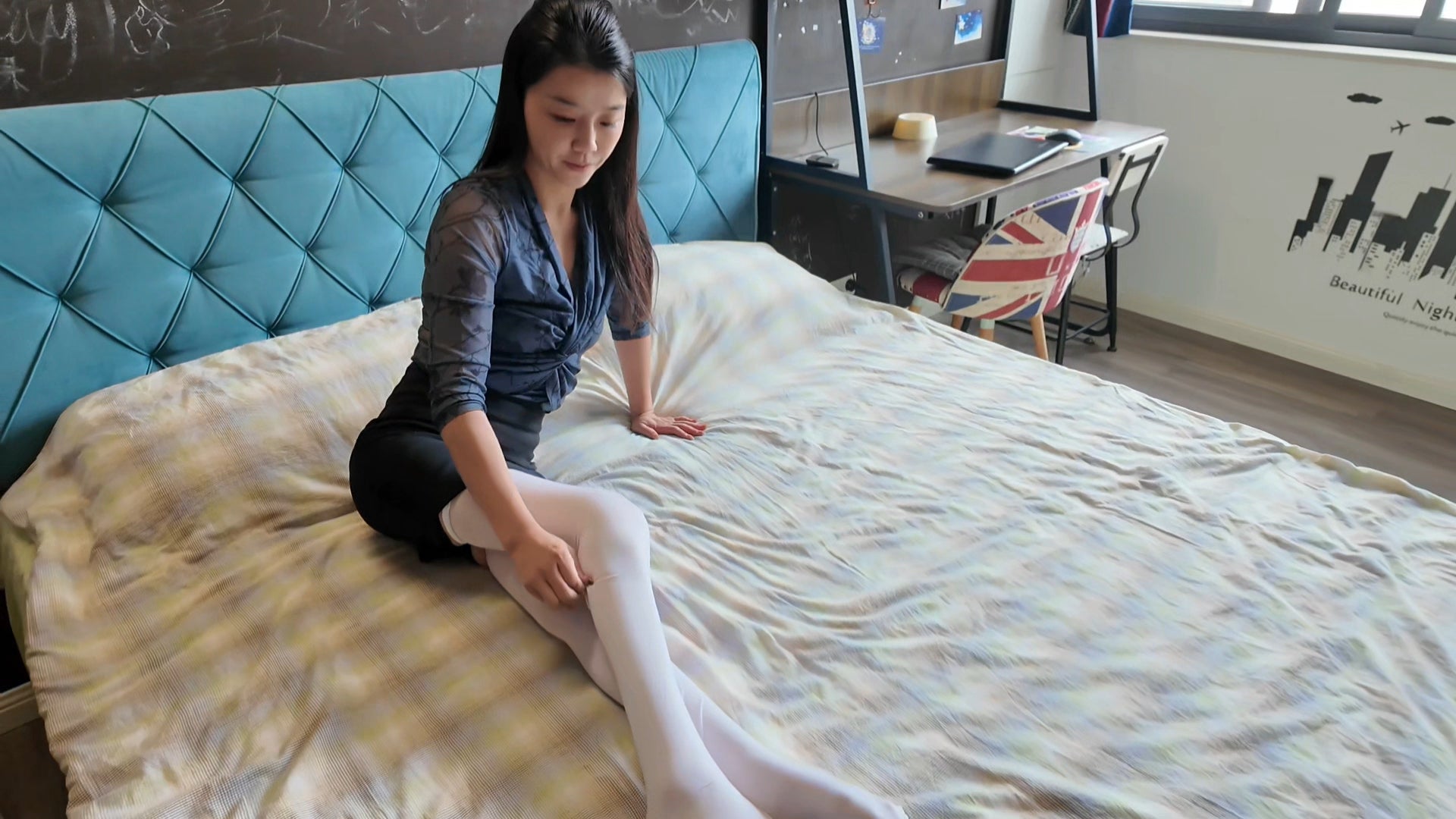 Belle: A paraplegic girl shows off white and black stockings while lying in bed.