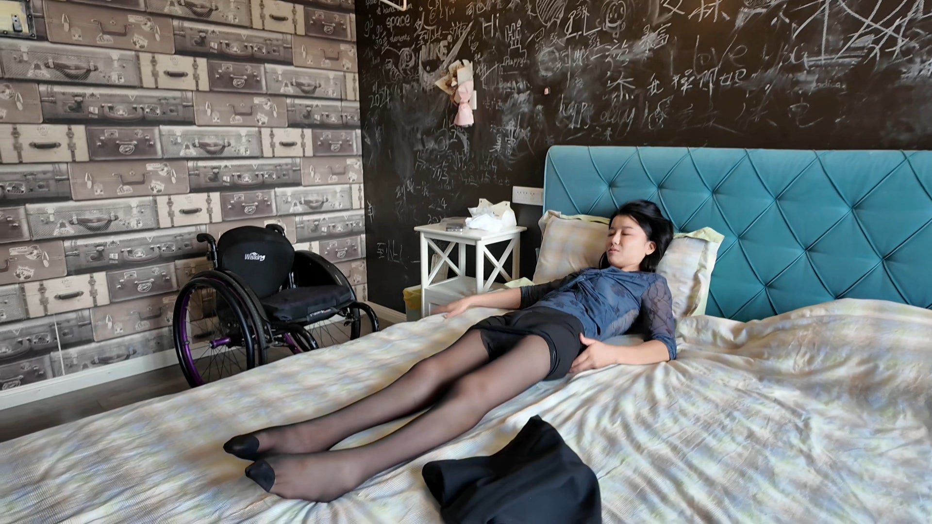 Belle: A paraplegic girl shows off white and black stockings while lying in bed.